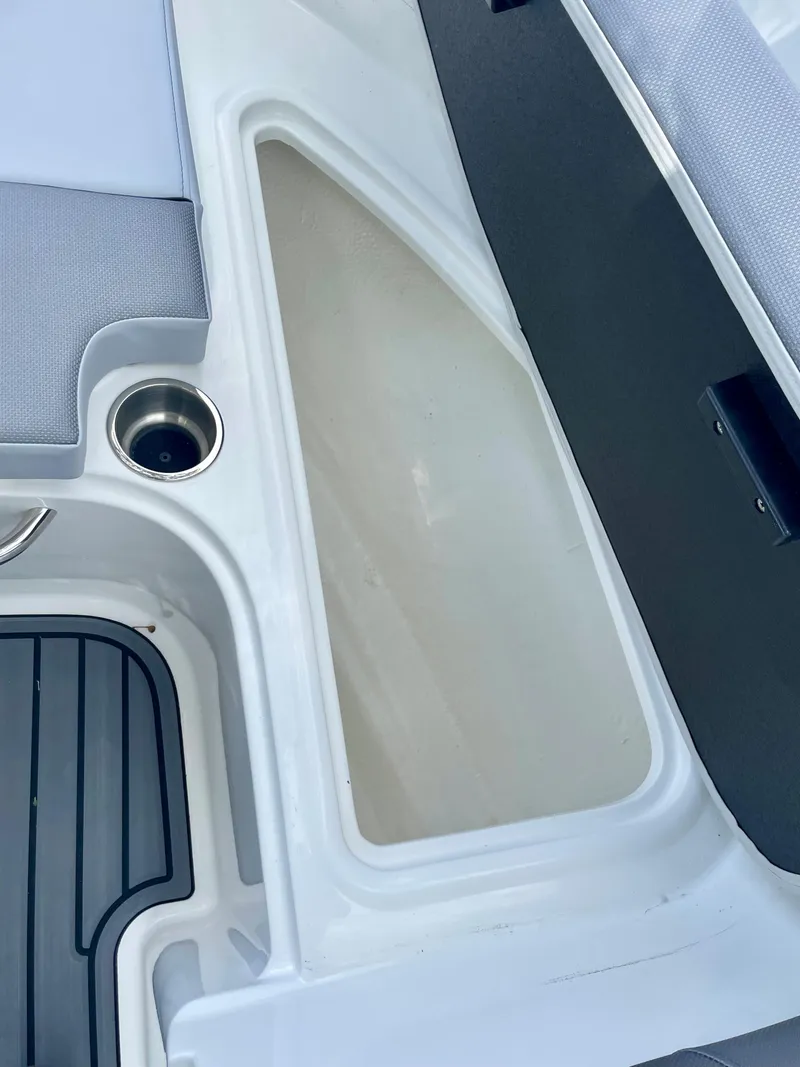 Slide: The Image of 2024 Bayliner VR4 boat interior storage compartment and cup holder. - 16