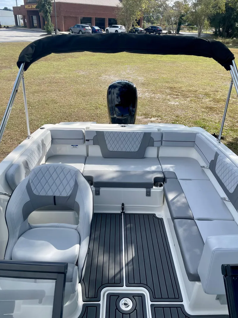 Slide: The Image of 2024 Bayliner VR4 boat interior with cushioned seating and black canopy. - 4