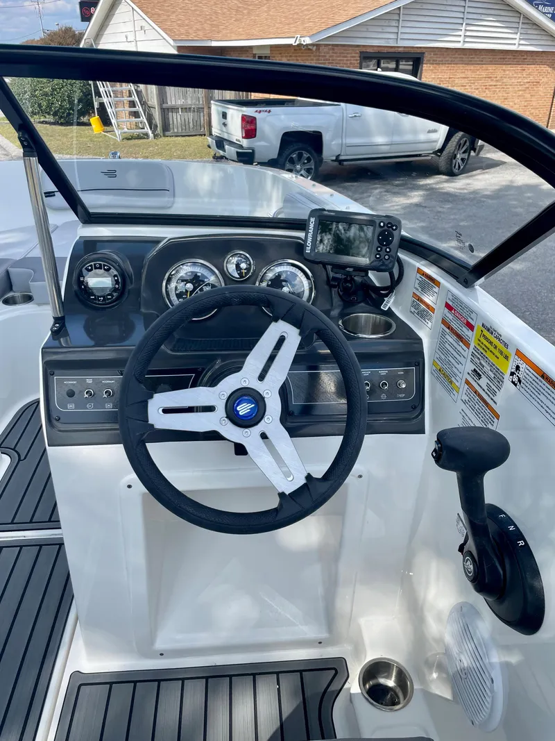 Slide: The Image of 2024 Bayliner VR4 boat dashboard with steering wheel and navigation controls. - 6