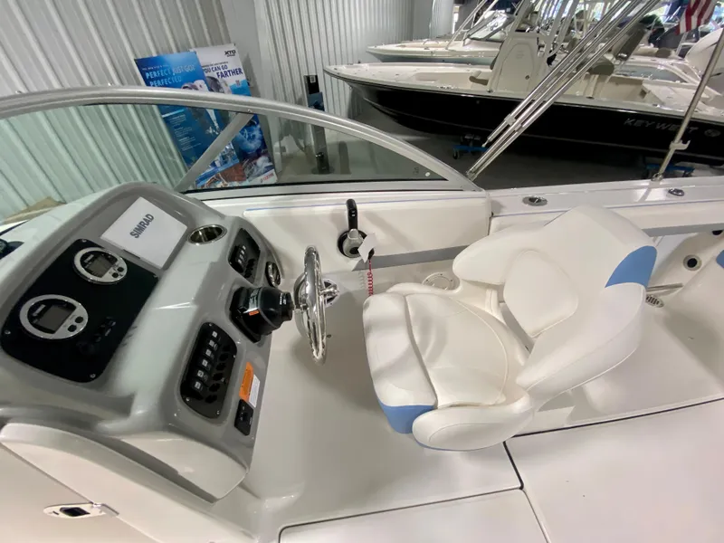 Slide: The Image of 2024 Robalo R207 Dual Console boat interior with steering wheel and captain's seat. - 12
