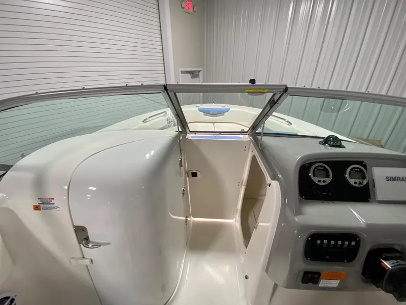 Slide: The Image of 2024 Robalo R207 Dual Console boat interior with dashboard and open bow access. - 17