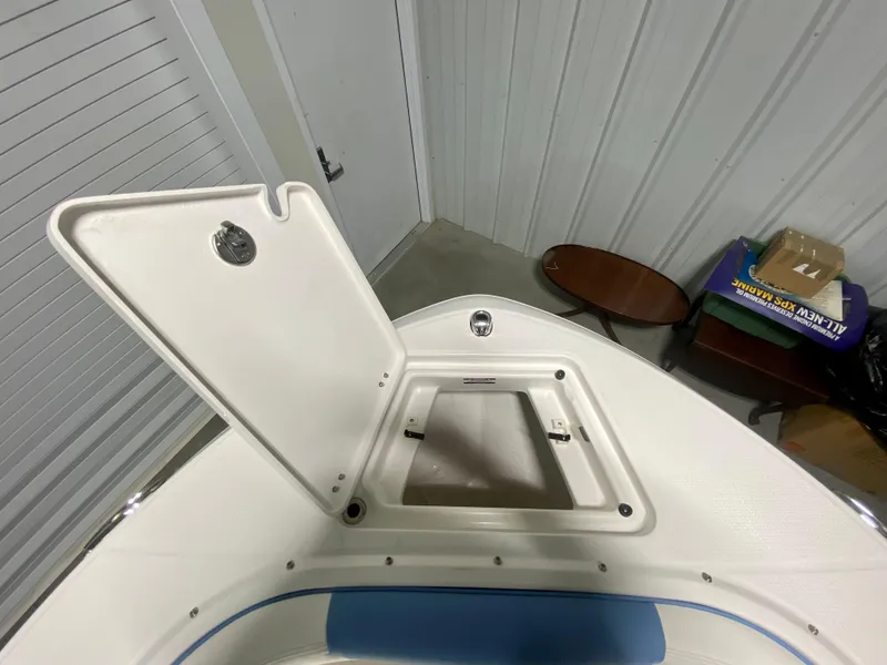 Slide: The Image of 2024 Robalo R207 Dual Console boat storage compartment with open hatch. - 25