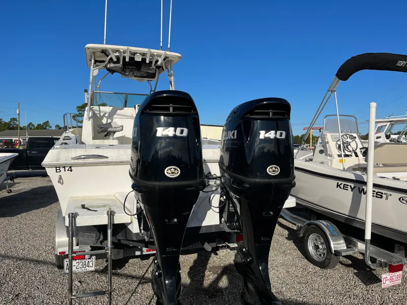 Slide: The Image of 1998 Sport-Craft 25 Walk Around boat with dual Suzuki 140 outboard motors, parked on gravel. - 3