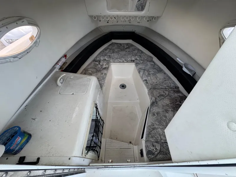 Slide: The Image of 1998 Sport-Craft 25 Walk Around cabin interior with storage and seating. - 4