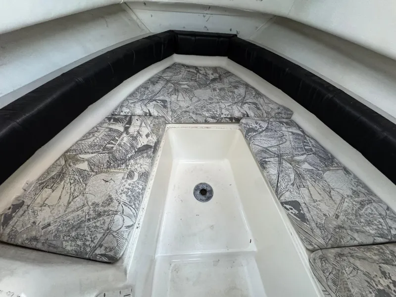 Slide: The Image of 1998 Sport-Craft 25 Walk Around boat interior with patterned cushions and black trim. - 5