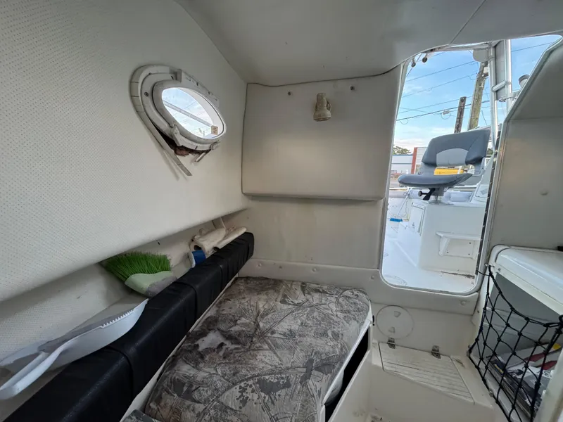 Slide: The Image of 1998 Sport-Craft 25 Walk Around cabin interior with seating and storage. - 6