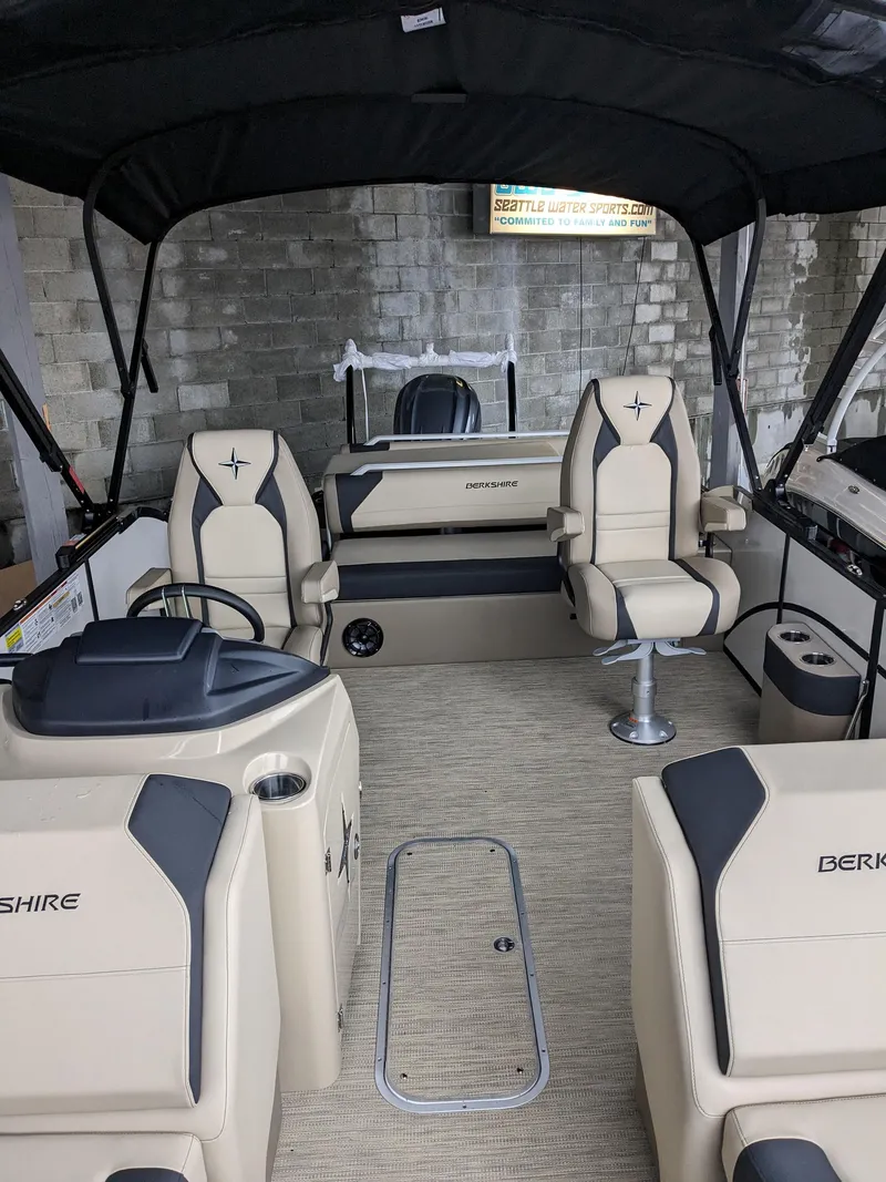 Slide: The Image of 2024 Berkshire 23ULE STS pontoon boat interior with beige and black seating. - 11