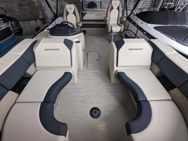 Slide: The Image of 2024 Berkshire 23ULE STS pontoon boat interior with beige and black seating. - 12