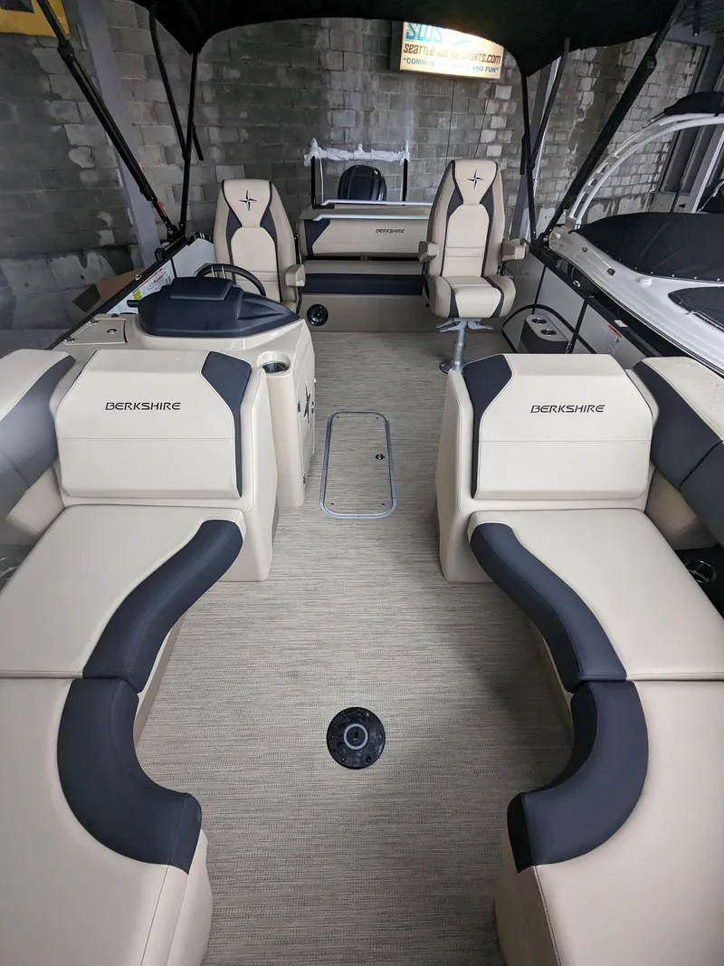 Slide: The Image of 2024 Berkshire 23ULE STS pontoon boat interior with beige and black seating. - 13