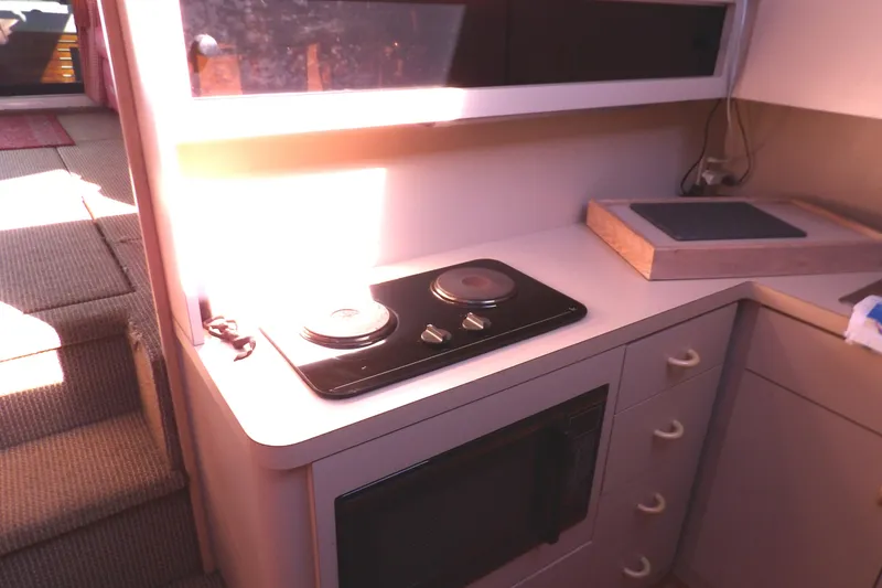 Slide: The Image of Compact kitchen area in a 1991 Silverton 41 boat with stove and microwave. - 42