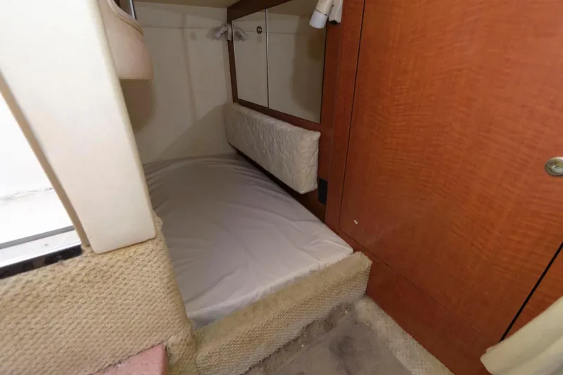 Slide: The Image of 2005 Sea Ray 280 Sundancer cabin interior with bed and storage. - 10