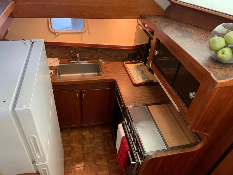 Slide: The Image of 1982 Trojan F 40 boat kitchen with sink, stove, and refrigerator. - 28
