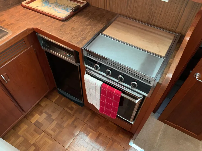 Slide: The Image of 1982 Trojan F 40 boat kitchen with stove, oven, and wooden cabinetry. - 29