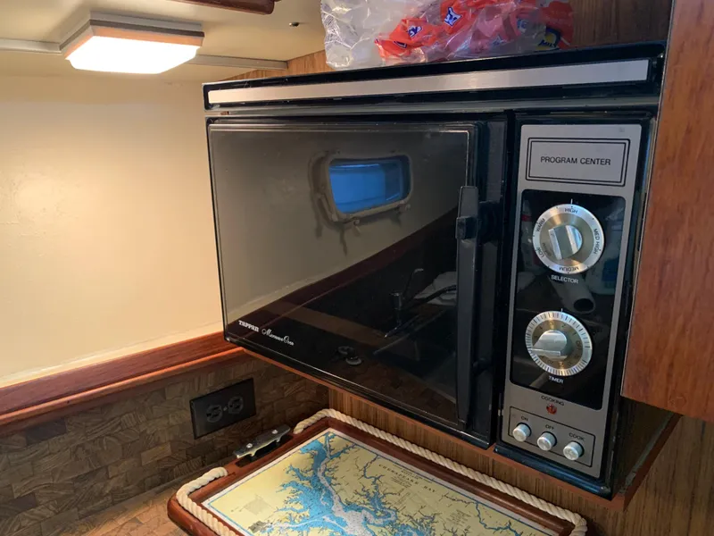 Slide: The Image of 1982 Trojan F 40 boat interior with microwave and nautical map. - 30