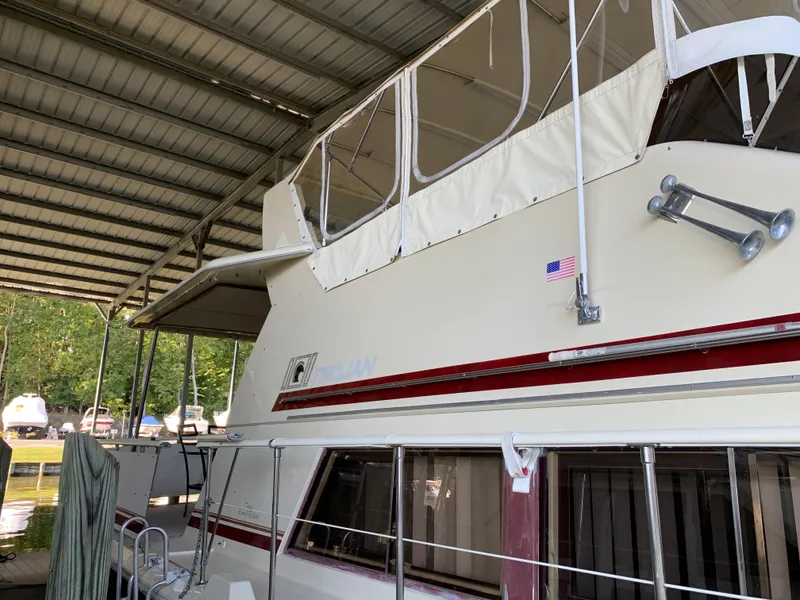 Slide: The Image of 1982 Trojan F 40 yacht under covered dock with American flag. - 6