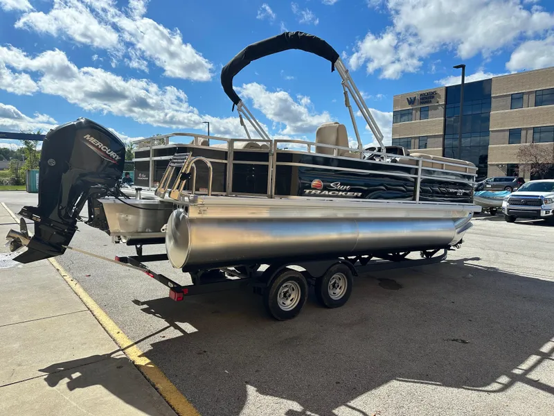 Slide: The Image of 2024 Sun Tracker SportFish 20 DLX pontoon boat on trailer, parked outdoors. - 3