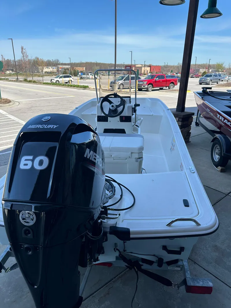 Slide: The Image of 2024 Mako Pro Skiff 15 CC with Mercury 60 outboard motor, docked outdoors. - 3