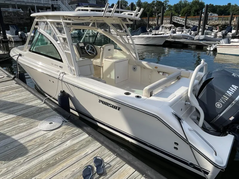 Slide: The Image of 2012 Pursuit DC 265 Dual Console boat docked at marina. - 3