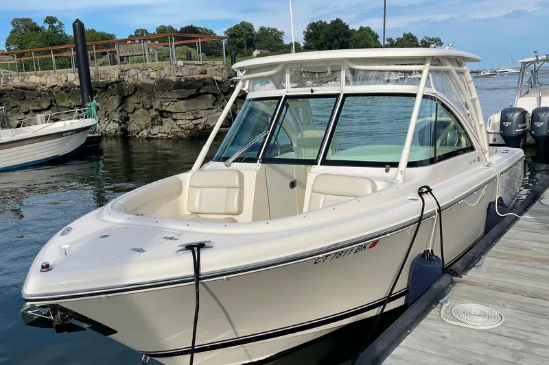 Slide: The Image of 2012 Pursuit DC 265 Dual Console boat docked at marina. - 8