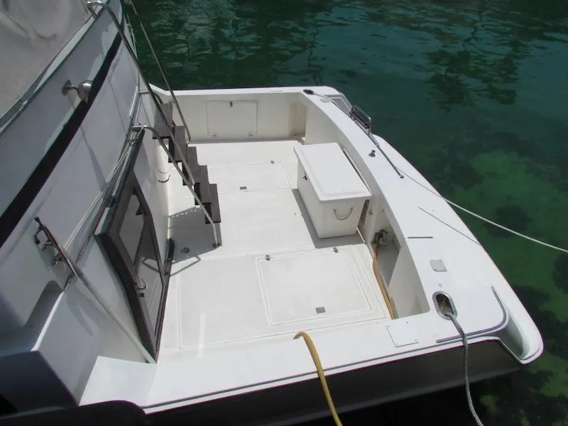 Slide: The Image of 1997 Hyatt 55 boat deck with seating and storage, docked on clear water. - 1