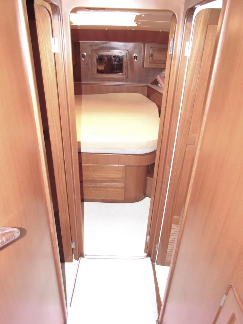 Slide: The Image of 1997 Hyatt 55 yacht interior cabin with wooden finish and cozy bed. - 12