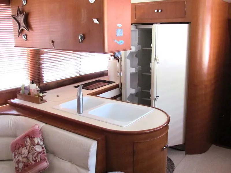 Slide: The Image of 1997 Hyatt 55 yacht kitchen with sink, fridge, and wooden cabinetry. - 19