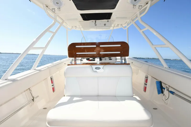 Slide: The Image of 2011 Pursuit S310 boat interior with white seating and ocean view. - 13