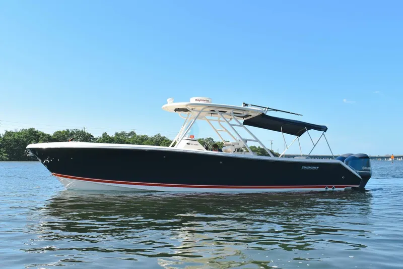 Slide: The Image of 2011 Pursuit S310 boat on calm water with clear blue sky. - 19