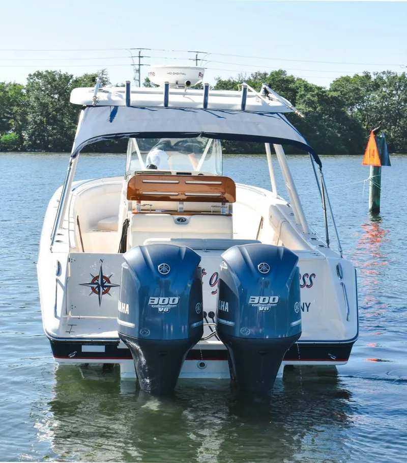 Slide: The Image of 2011 Pursuit S310 boat with twin Yamaha 300 engines on a calm lake. - 23