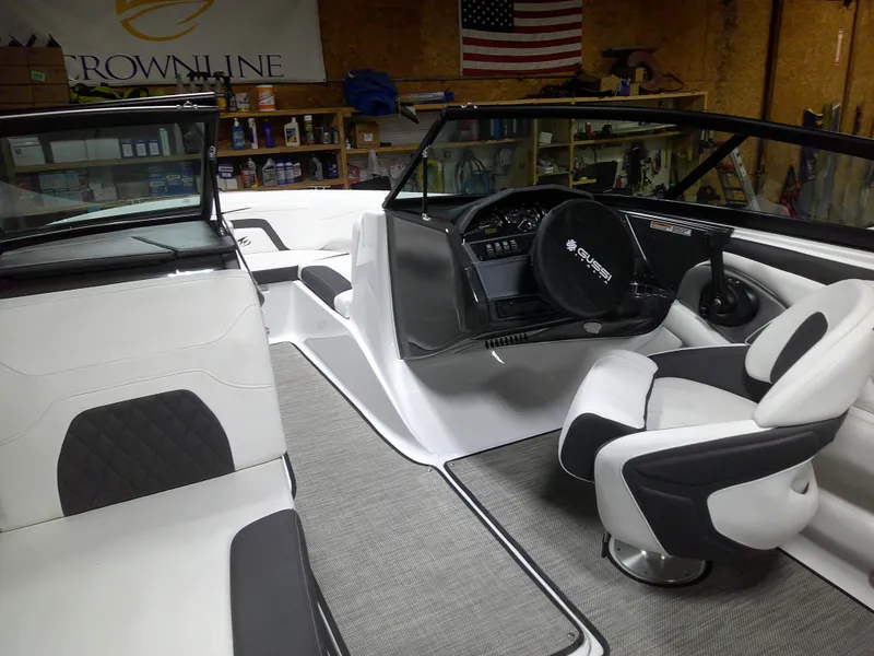 Slide: The Image of 2023 Monterey 224FS boat interior with steering wheel and seating in a garage. - 8