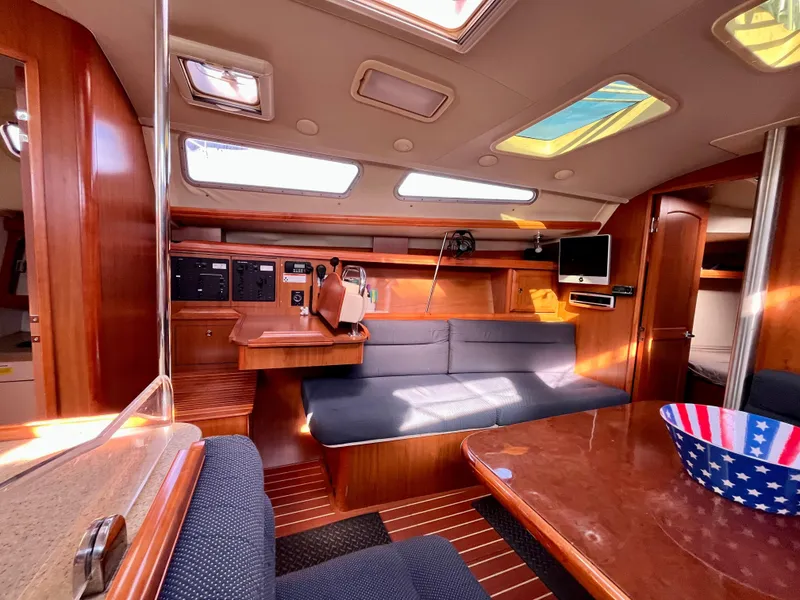 Slide: The Image of Interior of 2008 Hunter 38 sailboat with wood finish and seating area. - 17