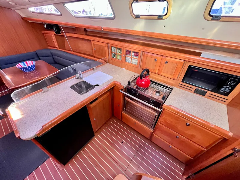 Slide: The Image of 2008 Hunter 38 yacht interior with kitchen, wooden cabinets, and dining area. - 18