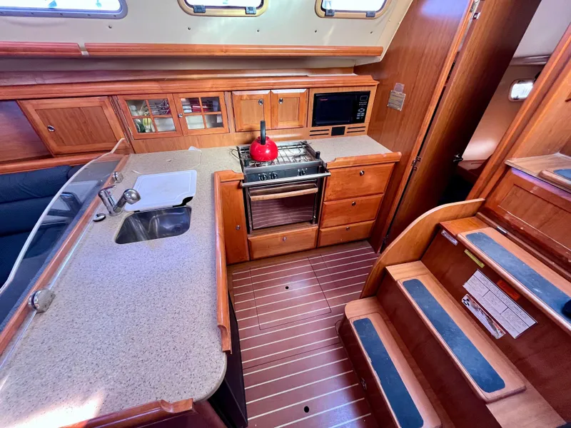 Slide: The Image of 2008 Hunter 38 yacht interior kitchen with wood cabinetry and modern appliances. - 19
