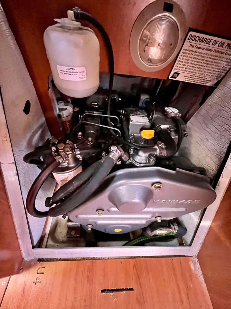 Slide: The Image of Engine compartment of a 2008 Hunter 38 sailboat, featuring mechanical components and fluid reservoir. - 28