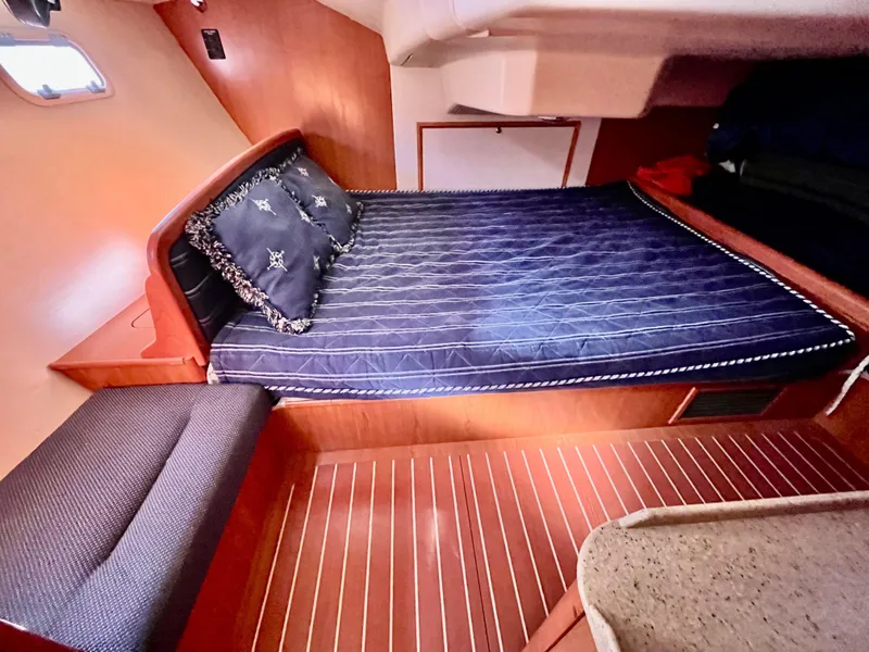 Slide: The Image of Cozy cabin interior of 2008 Hunter 38 sailboat with blue bedding and wooden flooring. - 5