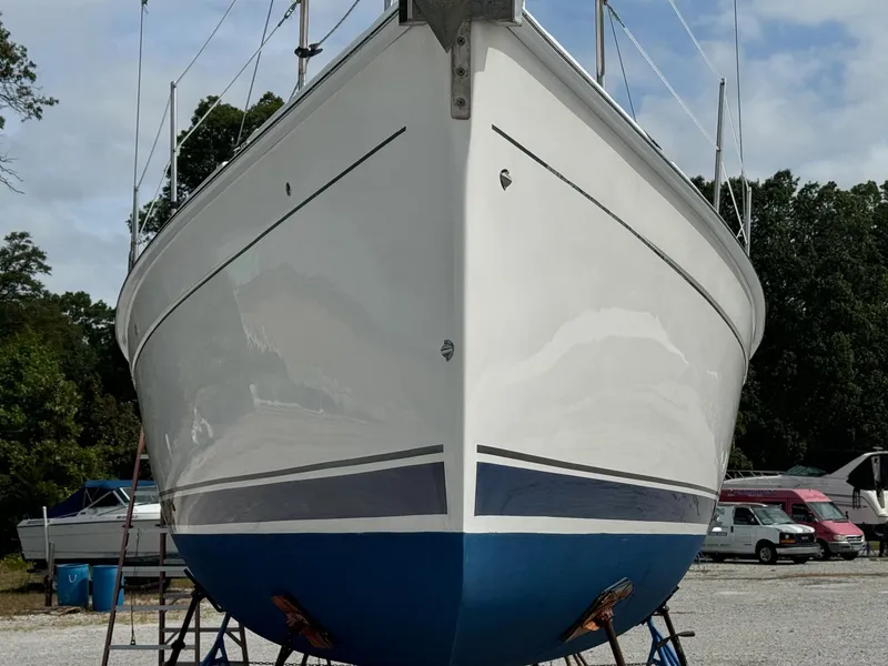 Slide: The Image of 2008 Hunter 38 sailboat on stands, white hull with blue bottom, outdoor storage. - 6