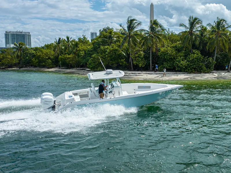 Slide: The Image of 2023 CG Boat Works 35 M-Series cruising near a tropical shoreline. - 2