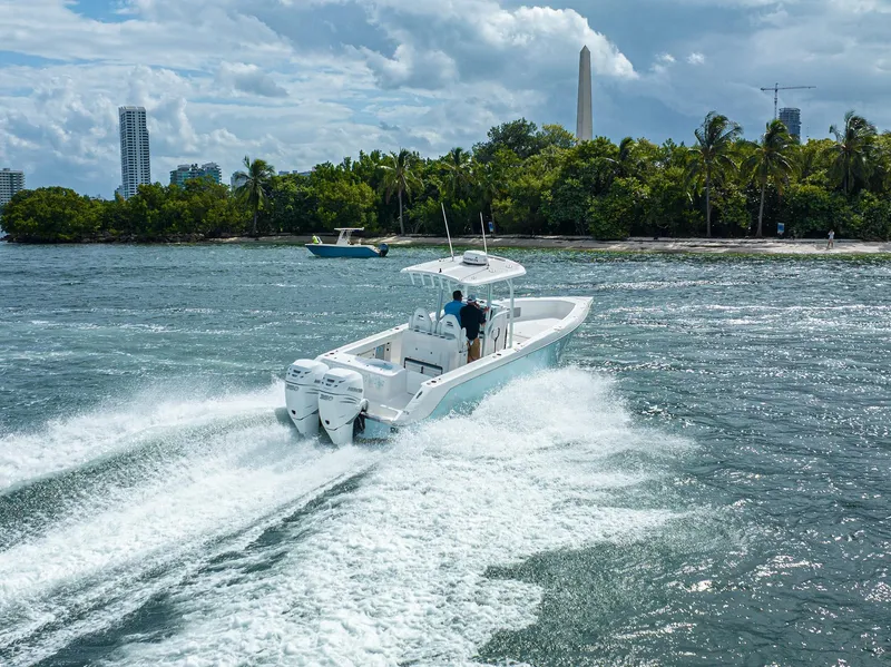 Slide: The Image of 2023 CG Boat Works 35 M-Series cruising on a sunny day near a tropical shoreline. - 3