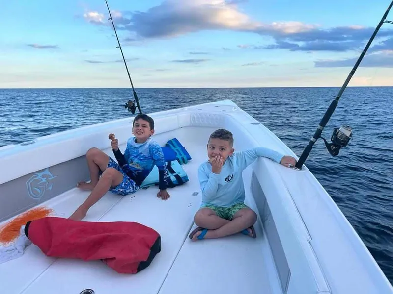 Slide: The Image of Two kids enjoying a fishing trip on a 2023 CG Boat Works 35 M-Series. - 33