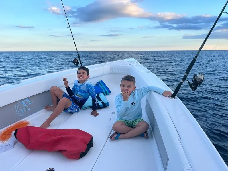 Slide: The Image of Two kids enjoying a fishing trip on a 2023 CG Boat Works 35 M-Series. - 40