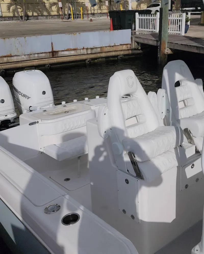 Slide: The Image of 2023 CG Boat Works 35 M-Series at dock, featuring white seating and twin Mercury engines. - 48