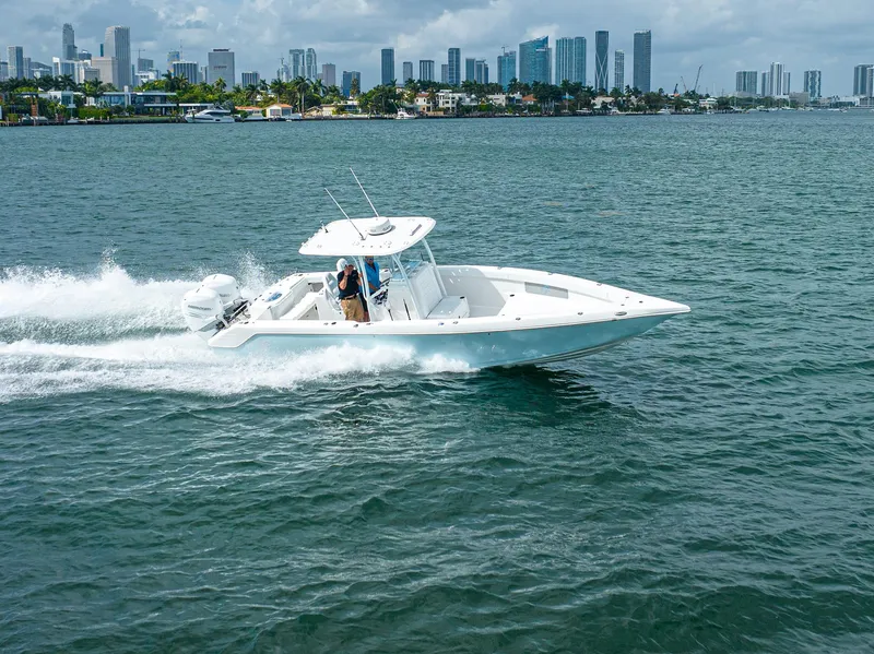 Slide: The Image of 2023 CG Boat Works 35 M-Series cruising on water with city skyline in background. - 6