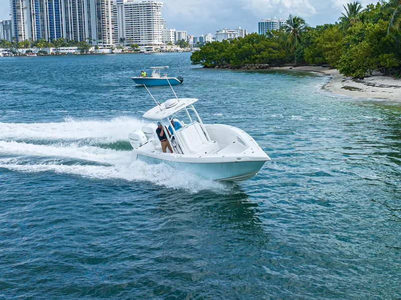 Slide: The Image of 2023 CG Boat Works 35 M-Series cruising near a city shoreline. - 9