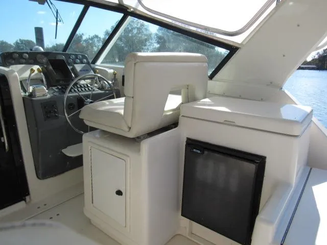 Slide: The Image of 1995 Tiara Yachts 3700 Open helm station with captain's chair and mini fridge. - 20