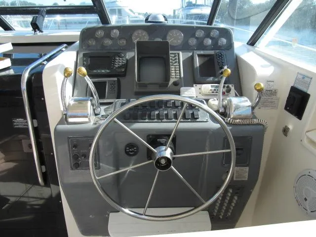 Slide: The Image of 1995 Tiara Yachts 3700 Open helm with steering wheel and navigation controls. - 21