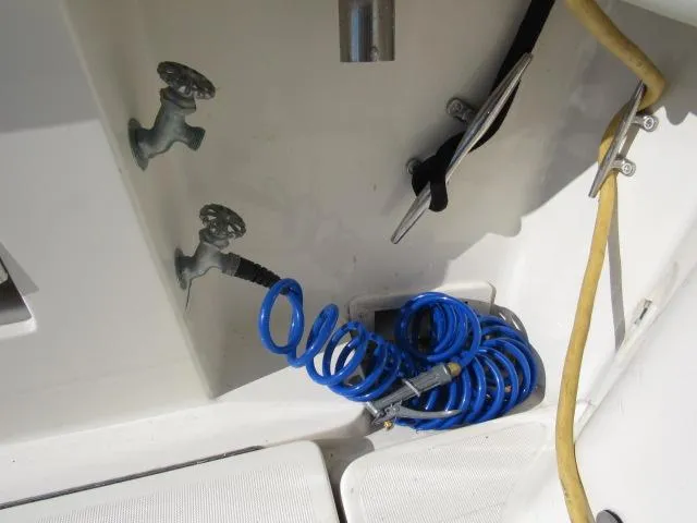 Slide: The Image of 1995 Tiara Yachts 3700 Open deck with coiled blue hose and water taps. - 26