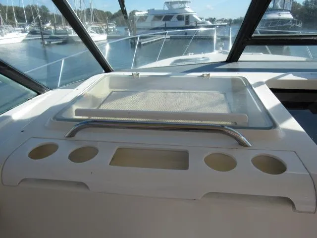 Slide: The Image of 1995 Tiara Yachts 3700 Open helm station with cup holders and storage compartments. - 27