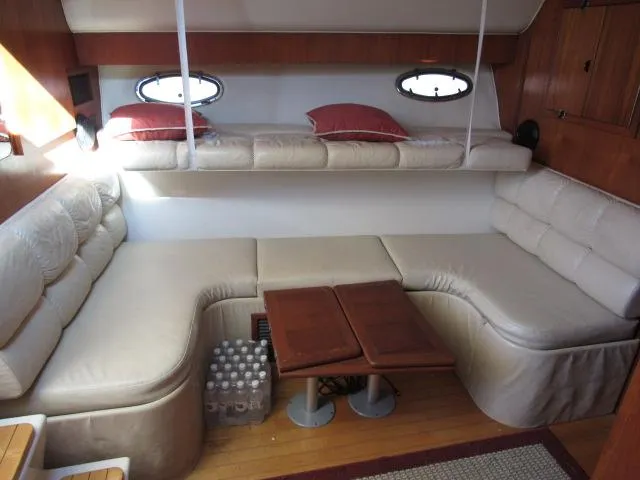 Slide: The Image of 1995 Tiara Yachts 3700 Open interior with beige seating and wooden table. - 32