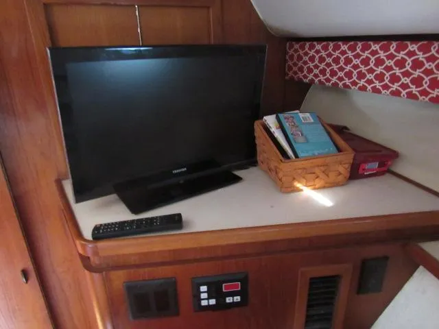 Slide: The Image of Flat-screen TV and remote on a Tiara Yachts 3700 Open 1995 model interior. - 33