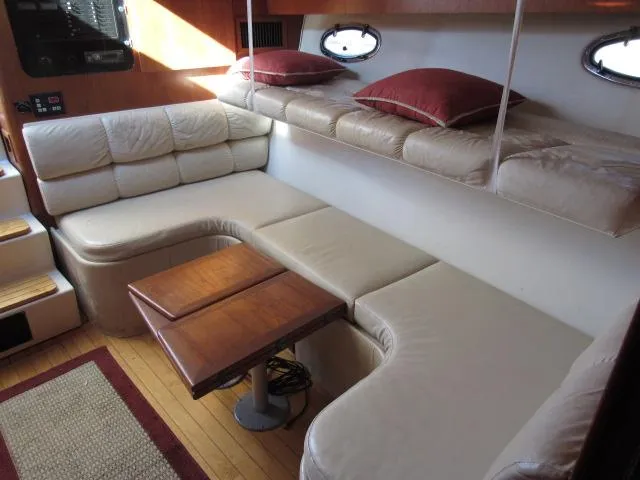Slide: The Image of 1995 Tiara Yachts 3700 Open interior with beige leather seating and wooden table. - 34